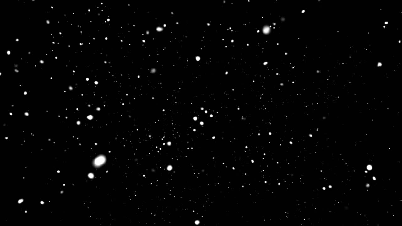 Beautiful overlay of heavy, soft-focus bokeh snow particles falling at various speeds and depths against an isolated black background
