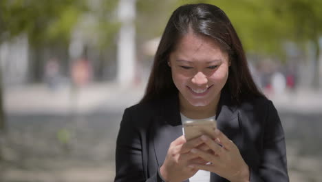 attractive happy girl using smartphone outdoor