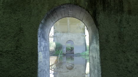 Nahaufnahme-Eines-Torbogens-Unter-Einer-Betonbrücke-In-Der-Nähe-Des-Flusses