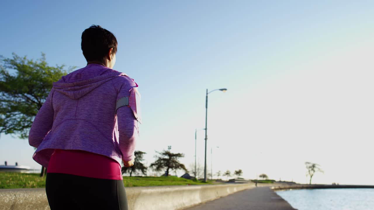 스마트폰으로 달리는 아프리카계 미국인 여성 해안선