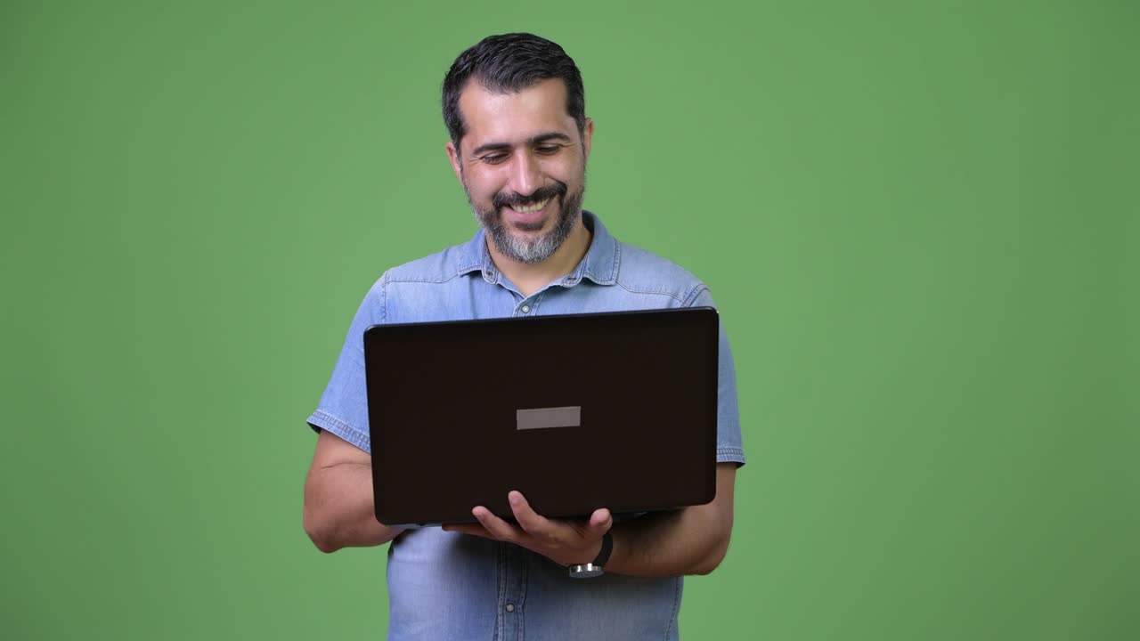 Handsome Persian bearded man using laptop