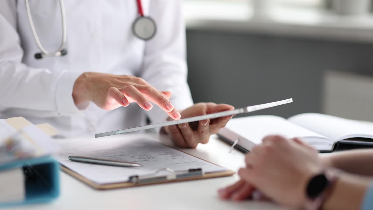 Doctor using a tablet during a medical consultation with a patient