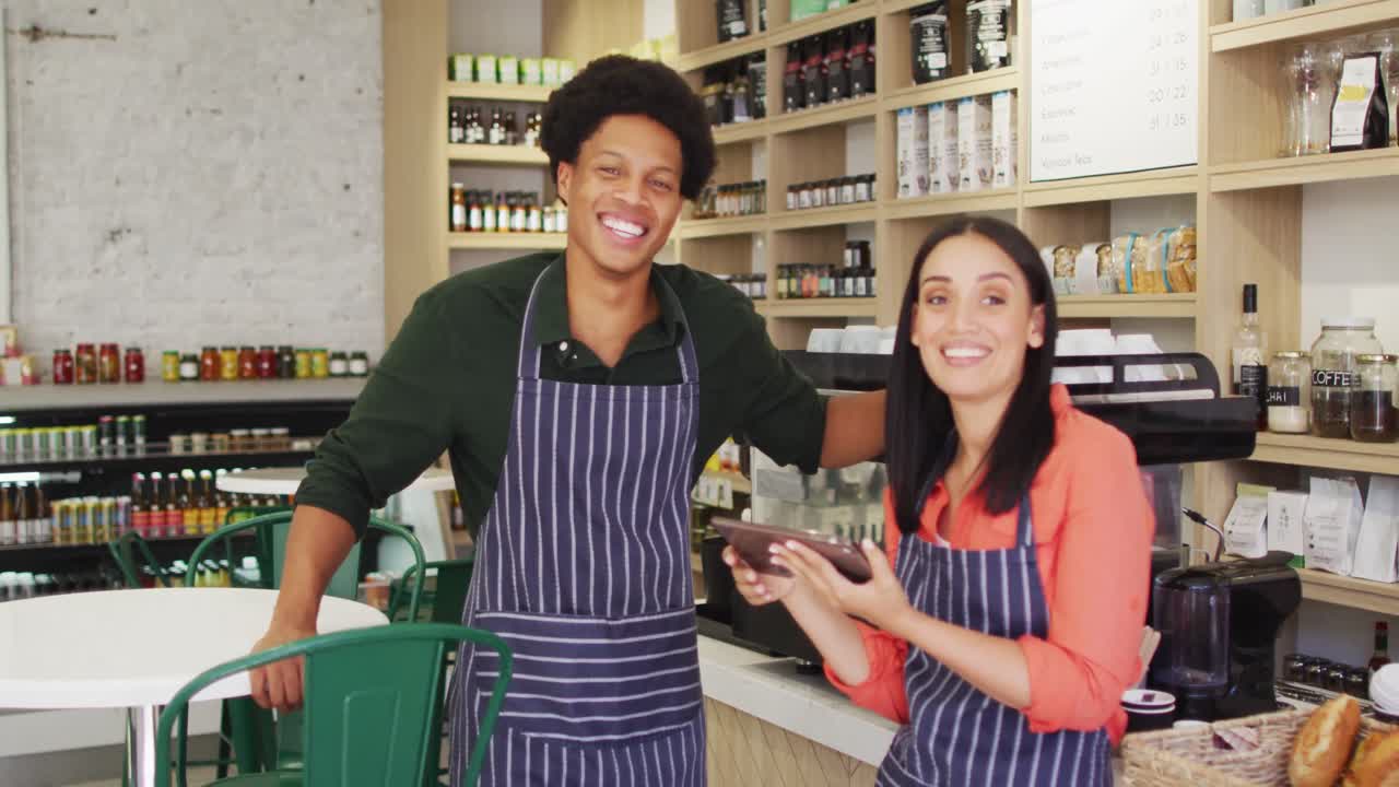 video de felices camareros femeninos y masculinos diversos en delantales en una cafetería