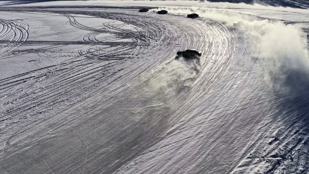 Drone luftfoto af en bil, der drifter på en frossen sø, kaster en enorm snesky og efterlader dækspor på vinterisoverfladen