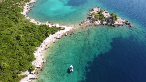 un dron aéreo ve un barco que se enfría en el mar adriático turquesa y cristalino a lo largo de la costa de dalmacia, croacia