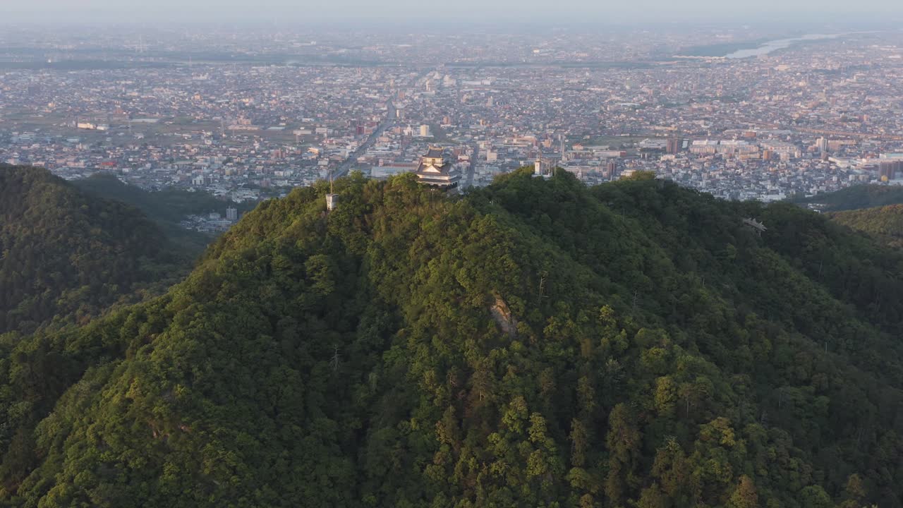 castillo gifu en mt kinka, antena lenta revela edificio antiguo y ciudad japonesa