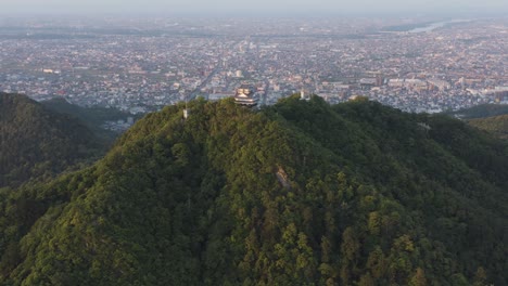 gifu castle on mt kinka, slow aerial reveal ancient building and japanese city