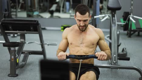 Atleta-Sin-Camisa-Entrenando-Máquina-De-Remo-Ejercicio-Intenso-Entrenamiento-De-Resistencia