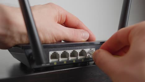 man plugging in a wifi router. close up