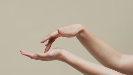 de manos de mujer asiática en fondo beige con espacio de copia, cámara lenta