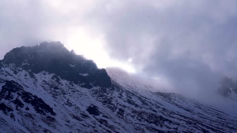 view of the peak of the nevado de toluca volcano near sunset with the sun behind clouds and a nice view of the snowy peak called pico del fraile