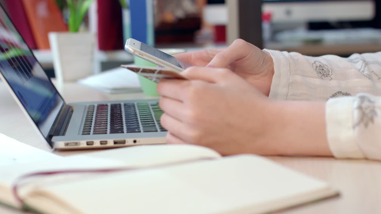 soluciones de pago móvil. manos de mujer sosteniendo tarjeta de crédito y usando teléfono inteligente