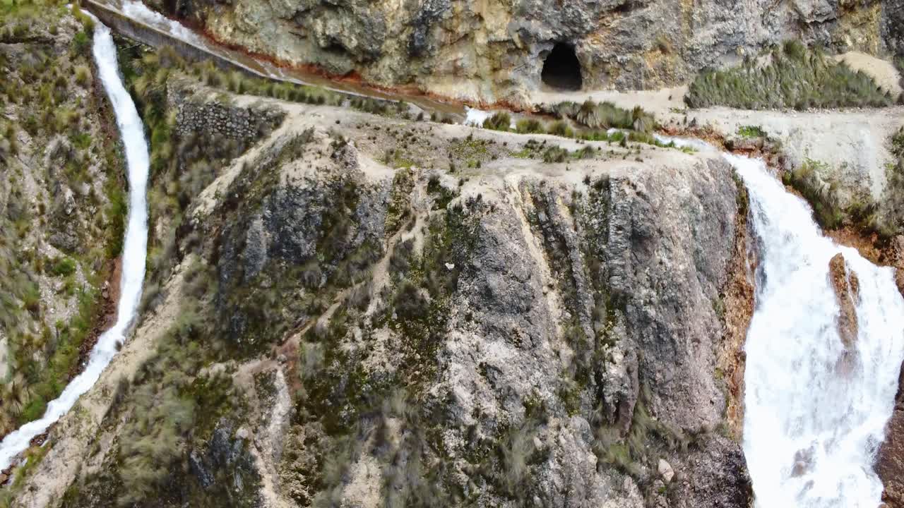 imágenes de drones de 4k que se alejan de la parte superior de una cascada formando dos canales de agua separados