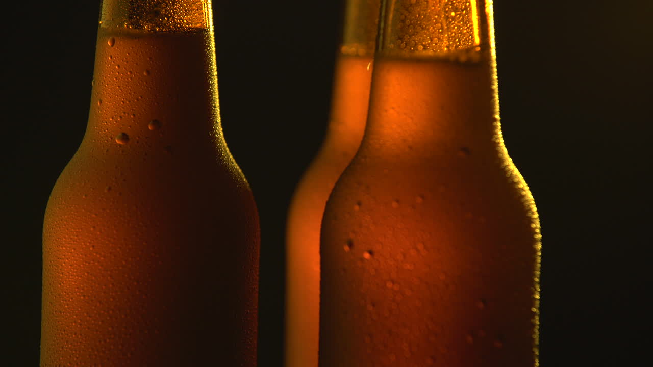 Three beer bottle rotating on black background