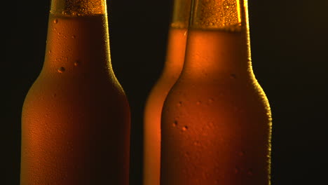 three beer bottle rotating on black background