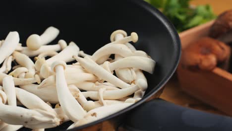 cooking white mushrooms in a pan