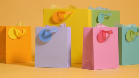 fotografía de estudio de coloridas bolsas de regalos para fiestas de cumpleaños contra un fondo amarillo 1