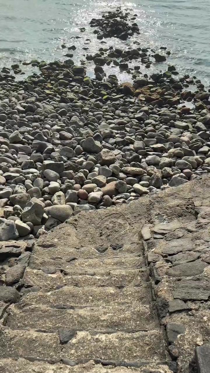 Gradini in pietra che conducono a una spiaggia rocciosa