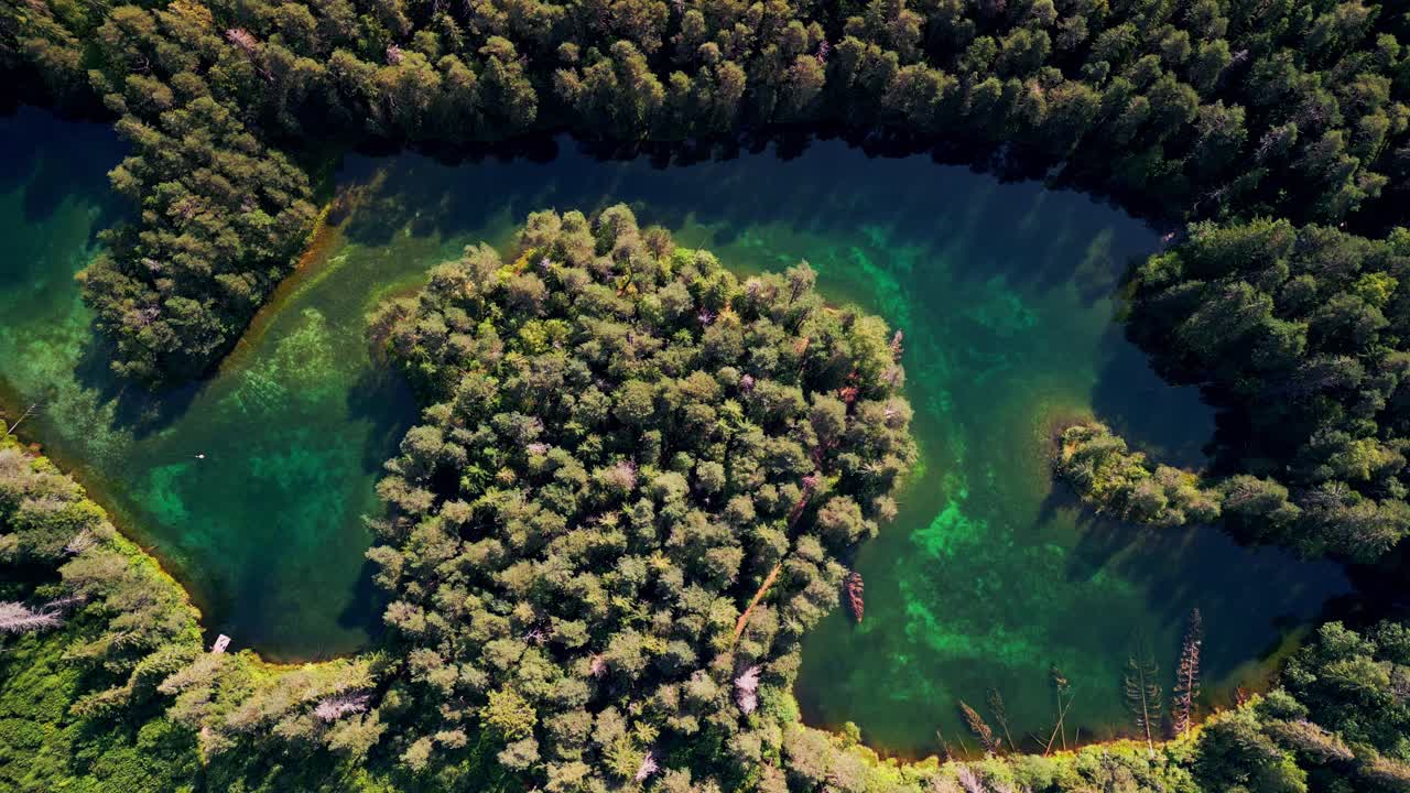 Aerial footage of Antu Sinijarv shows a vibrant turquoise lake nestled among trees with crystal clear water and peaceful surroundings offering a perfect view of untouched northern wilderness