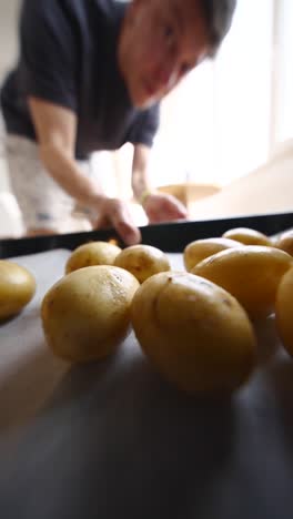 person preparing roasted potatoes in oven