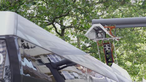 Close-up-of-pantograph-rising-from-the-roof-of-the-electric-bus