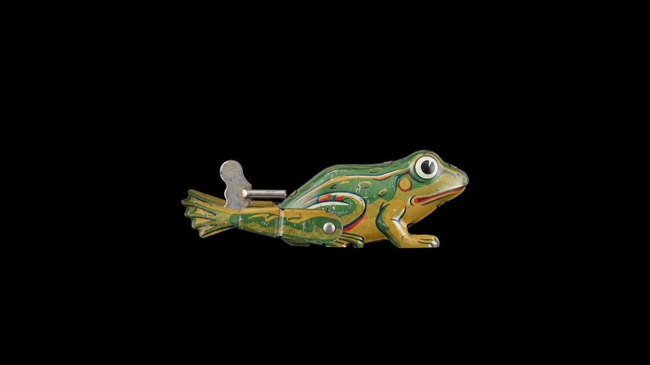 Vintage Tin Wind-Up Toy Frog Jumping on Black Background