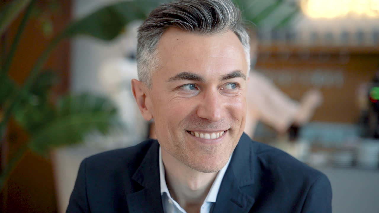 매력적인 사업가가 카메라를 직접 보고 웃는다