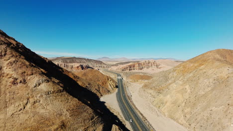 california highway 58 in the red rock canyons between tehachapi and barstow - pull back aerial reveal of the mojave desert