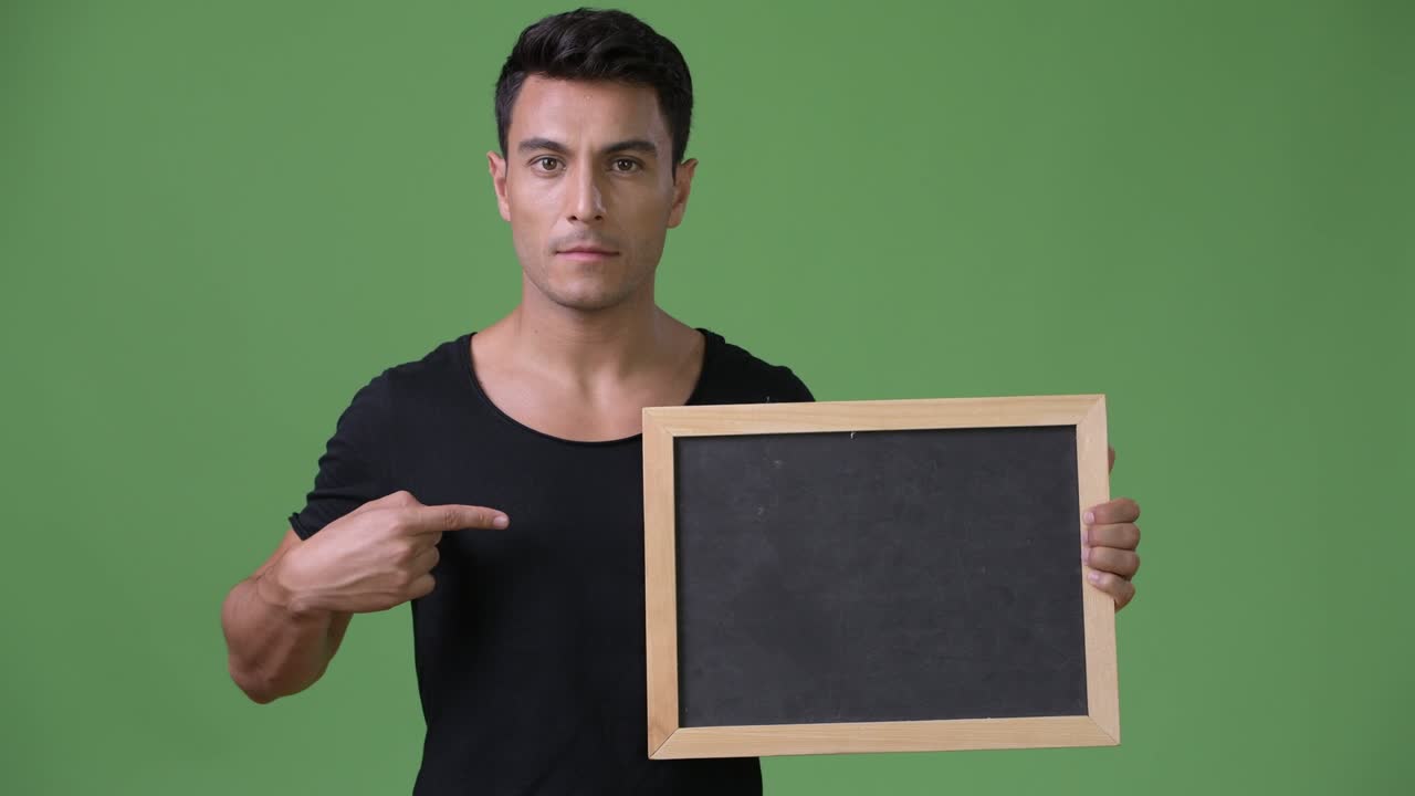 초록색 배경에 젊은 잘생긴 히스패닉 남자