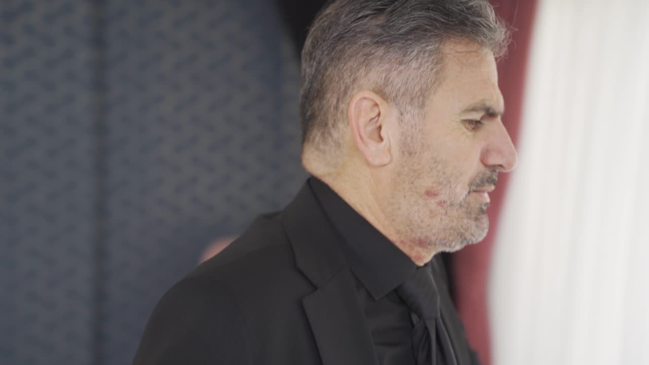 불행하고 우울한 사업가가 거울 앞에서 눈물을 흘리며 감정을 드러 ⁇ 니다.