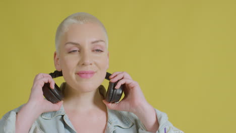 modelo caucásico femenino escuchando música con auriculares retrato de estudio 01