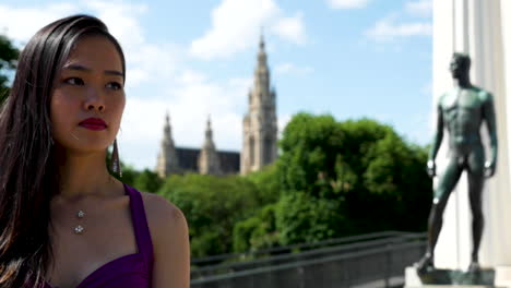 asian girl looking, rathaus at the back, vienna - slow motion