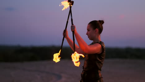 bailarines profesionales mujeres hacen un espectáculo de fuego y actuación pirotécnica en el festival con antorchas brillantes ardientes