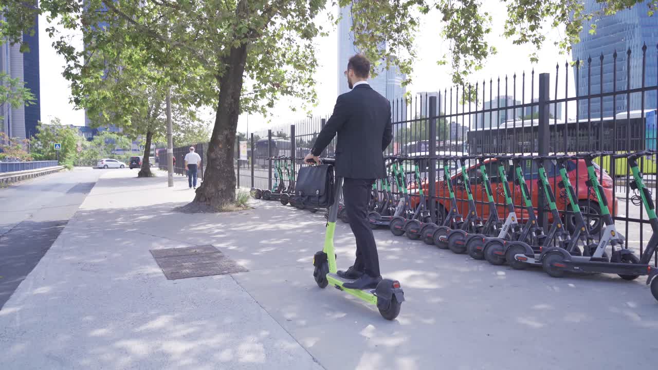 Joven empresario en patinete eléctrico al aire libre