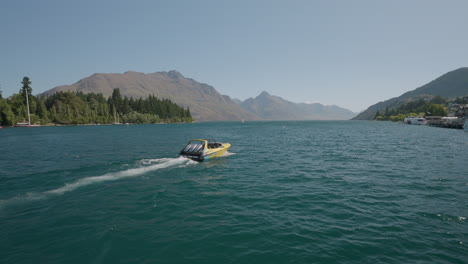 slow motion of shotover jet boat cruising across wakatipu lake in queenstown, new zealand