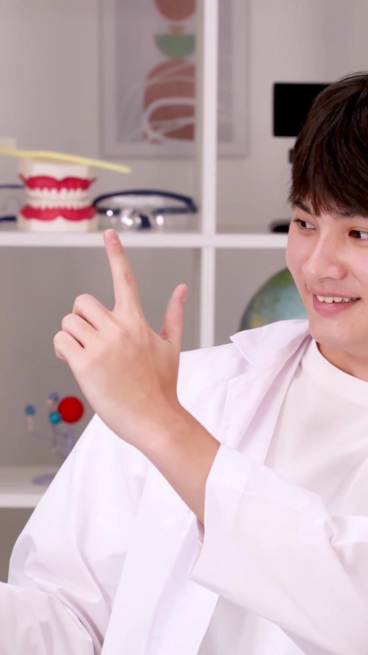 Young Asian Male Dentist Explaining Dental Care in Clinic