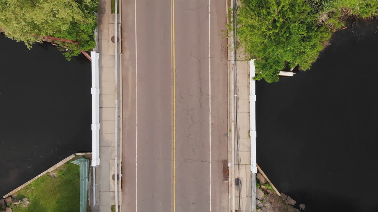 교외 지역의 작은 다리를 운전하는 외로운 자동차