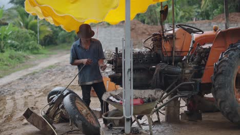 farmer repairing a tractor in a rural area