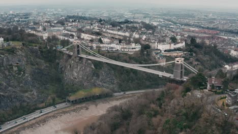 aerial shot of the clifton suspension bridge circling around over the river avon, bristol, during overcast cloudy day