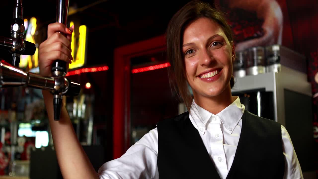 Lächelnder Barkeeper hält einen Bierhahn