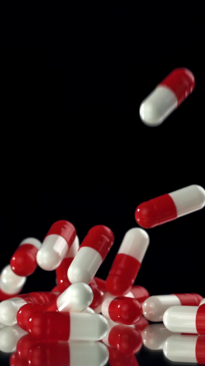 Capsule mediche rosse e bianche che cadono al rallentatore