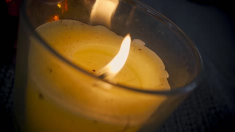 Yellow-wax-candle-in-glass-burning-in-slow-motion