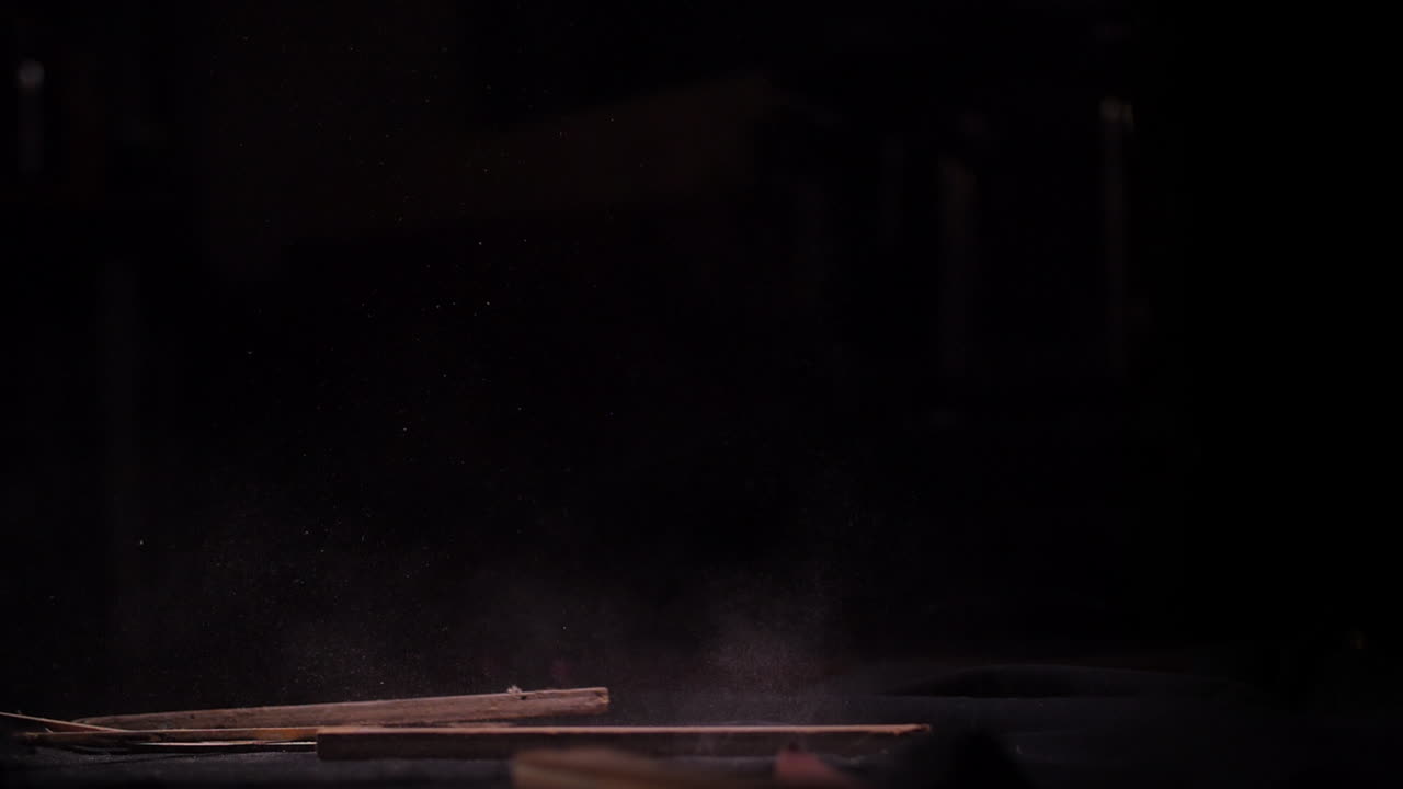 검은 스튜디오에서 땅에 떨어지는 오래된 먼지 투성이 스크랩 나무