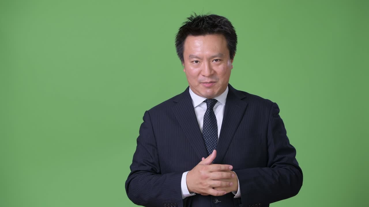 녹색 배경에 성숙한 일본 사업가