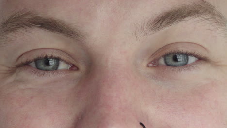 close-up-of-man-blue-eyes-looking-happy-at-camera-reflection-on-iris-nose-ring