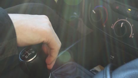 close up of hand on stick shift while driving then shifting to fourth gear