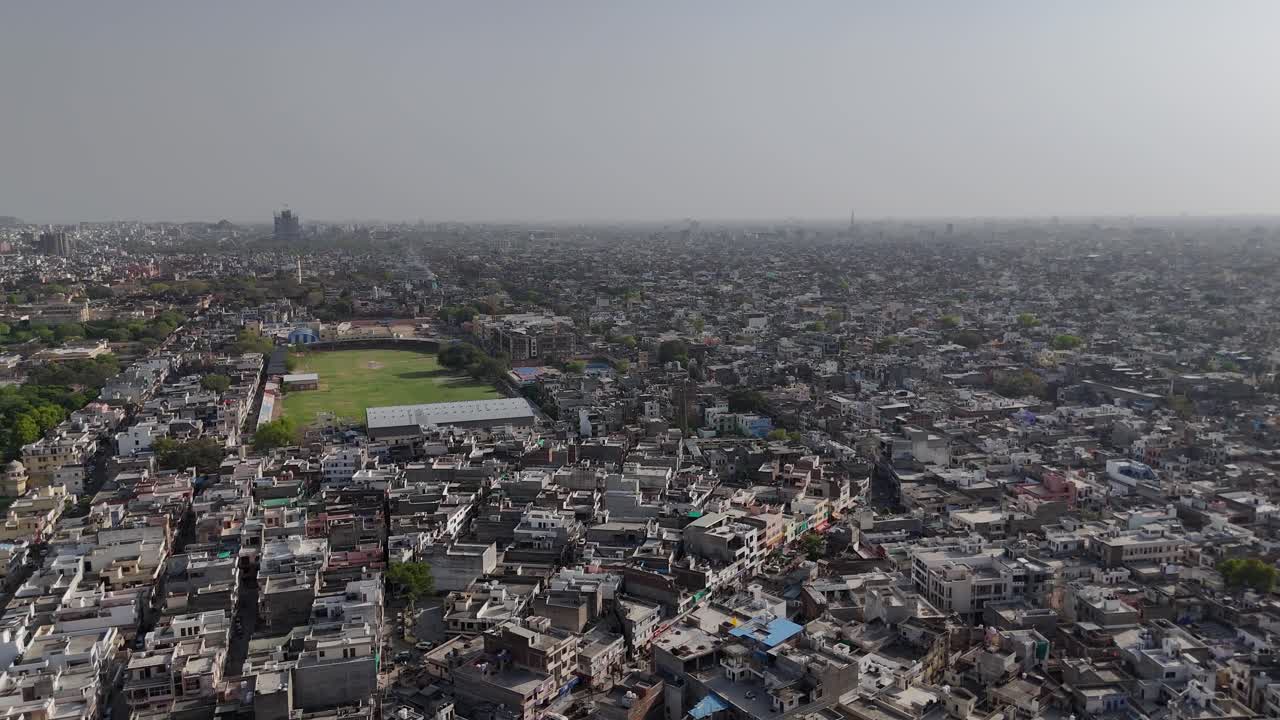 Overhead view of the rugged hills framing Jaipur's dense urban core with cricket ground