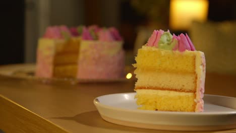 person putting down slice of party celebration cake for birthday decorated with icing on table at home 1