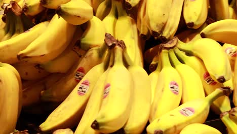 bright yellow bananas stacked in a supermarket, under warm lighting, creating a vibrant and fresh atmosphere