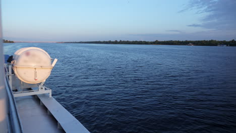 view from a boat deck with a lifeboat on a river